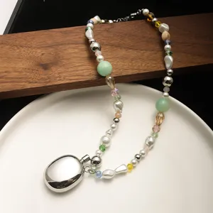 Close-up of Y2K style necklace with colorful beads, pearls and silver pebble pendant