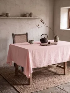 Elegante rosafarbene Tischdecke aus gewaschener Baumwolle auf rustikalem Holztisch