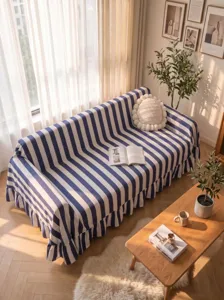 Cozy blue and white striped sofa cover with elegant ruffled edges in a sunlit room