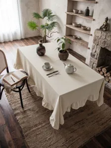 Dettaglio tovaglia in cotone lavato crema con eleganti bordi a volant