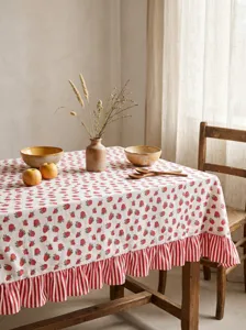 Rustic cream tablecloth with strawberry pattern and red striped ruffled edge detail