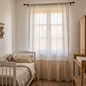 Minimalistische gestreifte Vorhänge in einem gemütlichen Kinderzimmer mit warmem Licht.