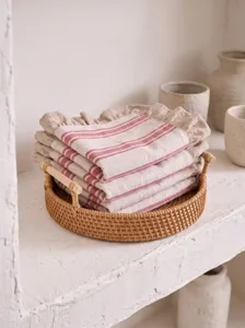 Close-up of rustic red striped linen napkins with ruffled edges in a rattan tray