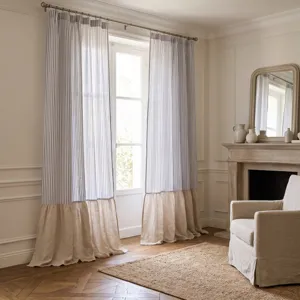 Détail de rideaux en lin rayés avec volant beige dans un salon au style classique