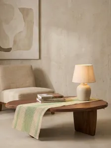 Détail d'un chemin de table rustique en papier tissé rayé sur une table basse en bois.