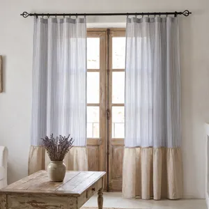 Détail de rideaux à rayures bleues et blanches avec un ourlet à volants beige rustique