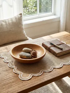 Retro linen-style placemat with white scalloped embroidery on a natural wooden table