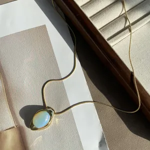 Detail shot of a vintage gold snake chain necklace with a natural opal oval pendant.
