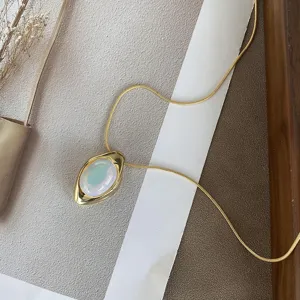 Detailed view of oval opal agate pendant with iridescent sheen on gold snake chain.