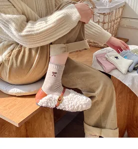 Detalle de calcetines de algodón grueso a media pantorrilla con bordado de lazo