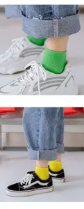 Nahaufnahme von bunten Baumwollkurzsocken, getragen mit trendigen Sneakers, Frühlingsstil.