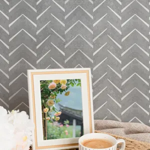 Detalle adhesivo de pared chevron gris, patrón texturizado autoadhesivo decoración hogar.