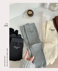 Macro view of cotton split-toe socks in multiple colors with embroidered text