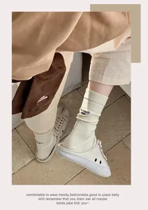 Cream mid-calf split-toe tabi socks featuring March Much embroidery and canvas shoes
