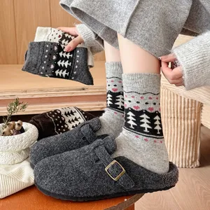 Close-up of thick Fair Isle wool socks with tree pattern and grey felt clogs for winter.