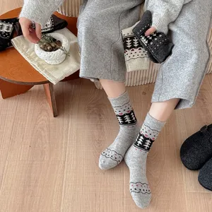 Close-up of warm gray Fair Isle wool socks with Christmas tree pattern on a model.