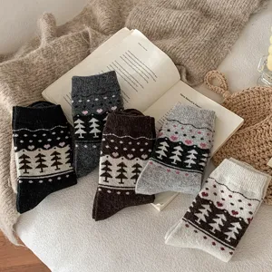 Close-up of Fair Isle wool socks with tree and heart patterns in various vintage colors.