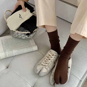 Breathable cotton two-toe tabi socks for women in brown paired with casual sneakers
