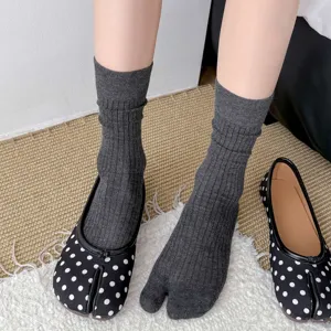 Detail shot of women's gray split toe mid calf socks paired with polka dot tabi shoes.