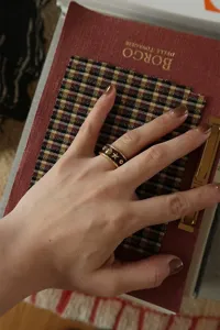 Κοντινό πλάνο ενός επιχρυσωμένου δαχτυλιδιού σμάλτου με αστερία φορεμένο στο χέρι