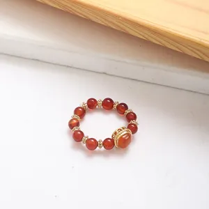 Detailed view of red agate beaded ring featuring elegant gold-tone spacers and accent