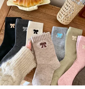 Primer plano de calcetines de algodón acanalados en varios colores con lindos lazos bordados