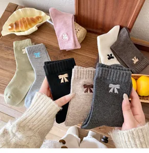 Detalle de los bonitos calcetines de algodón a media pierna con lazo bordado en varios colores.