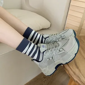Calze a righe larghe bianche e blu in cotone stile preppy indossate con scarpe da ginnastica