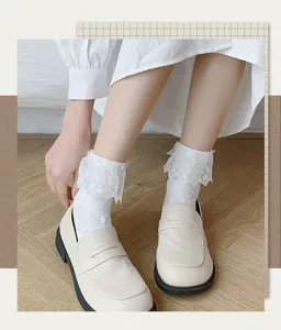 Detailed closeup of sweet Japanese style white lace ruffle mid-tube socks paired with casual loafers.