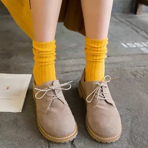 Cómodos calcetines de canalé de color liso combinados con zapatos retro elegantes.