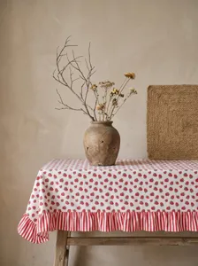 Detail of pastoral strawberry pattern tablecloth with elegant ruffled striped edge