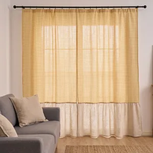 Detailansicht gelber Karo-Vorhang mit gerafftem beigem Leinensaum in einem Wohnzimmer