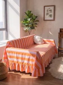 Striped fleece sofa cover with elegant ruffle edges displayed in a warm sunlit living room