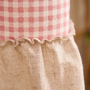Detalle macro de la cortina de cuadros de algodón y lino con vichy rosa y borde con volantes