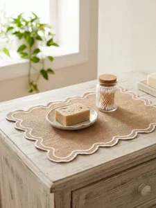 Rustic beige scalloped embroidered placemat displayed on a distressed wooden tabletop setting