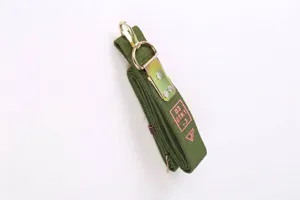 Macro view of heavy-duty green tactical strap featuring pink OTK markings and metal buckle