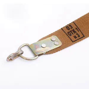 Macro view showing the metal hook and rivet detail on a durable brown tactical strap webbing