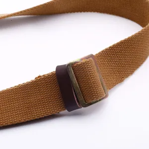 Close-up of durable tan canvas tactical strap with vintage metal adjustment buckle