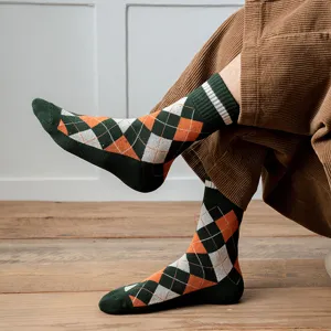 Detailed view of men's thick argyle crew socks in green and orange thermal knit fabric