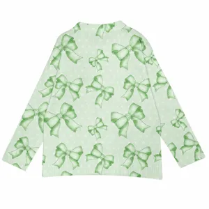 Detail view of the soft knit fabric and green bow print on the long-sleeved sweater.