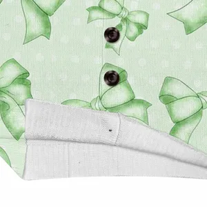 Close-up macro detail of light green knit cardigan with bow print and button texture