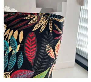 Detailopname van een canvas draagtas in etnische stijl met kleurrijke bladmotieven