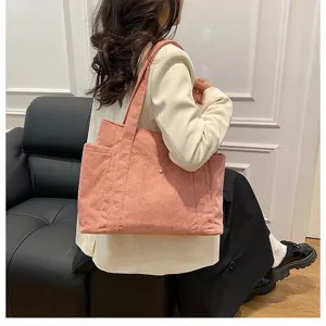 Grande borsa tote in velluto a coste rosa per donna mostrata su una modella seduta