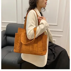 Elegante modella con una grande borsa tote in velluto a coste marrone alla moda