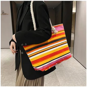 Close-up van een kleurrijke etnische gestreepte canvas shopper met touwhandvat op een model