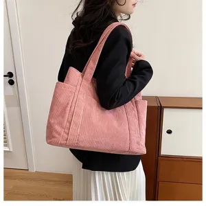 Dettaglio borsa tote in velluto a coste rosa con trama a costine e tasca laterale grande