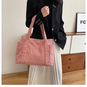 Borsa tote rosa in velluto a coste di grande capacità mostrata su un modello in interni