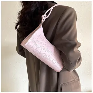 Back view of a stylish pink croc-embossed underarm bag paired with a brown blazer jacket