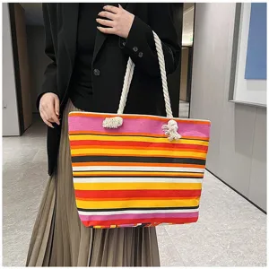Kleurrijke gestreepte canvas draagtas met touwhandvatten gedragen door een model