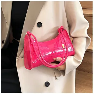 Close-up detail of a vibrant hot pink crocodile embossed underarm shoulder bag for women